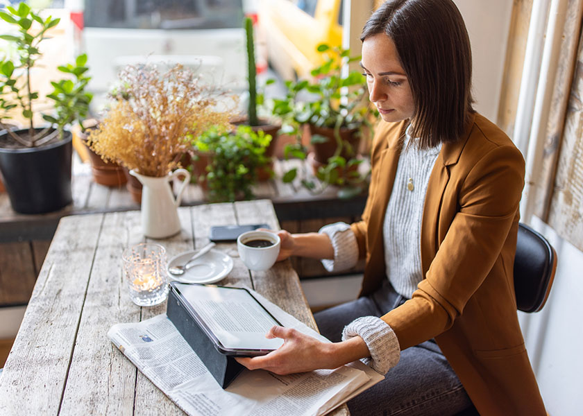 Woman reading on a tablet at a cafe