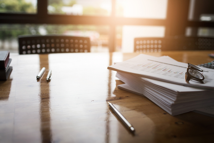 Stack of papers and pens lying on a business conference table